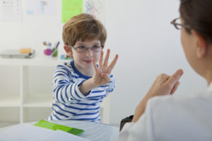 Boy holding up four fingers